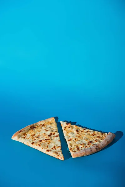Крупным планом кусочки вареной пиццы, изолированные на голубом фоне — стоковое фото