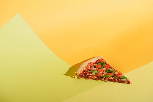 Close up view of piece of pizza with cherry tomatoes and basil on colorful backdrop — Stock Photo