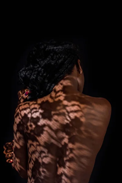 Visão traseira da jovem mulher americana africana com sombra floral em costas nuas — Fotografia de Stock