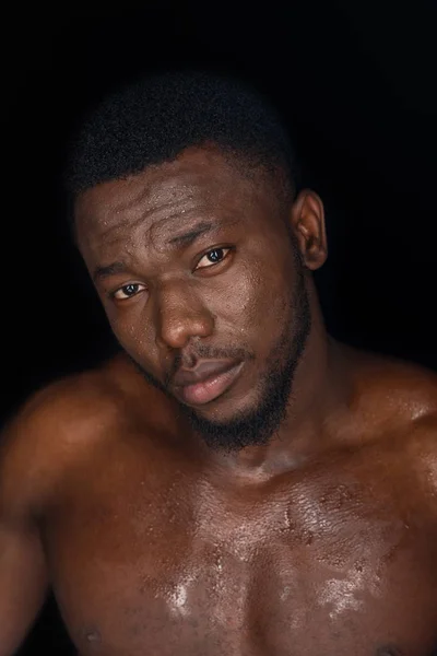 Handsome sweaty young african american man looking at camera isolated on black — Stock Photo