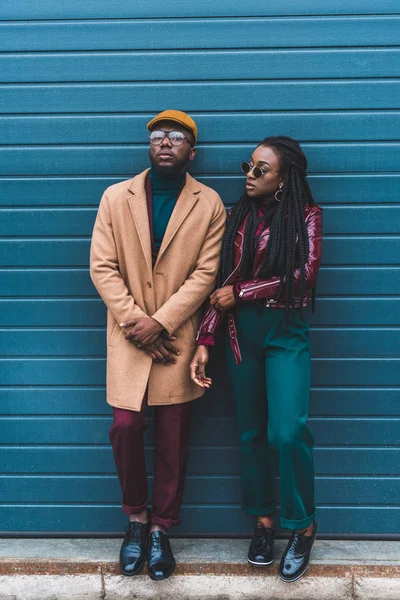 Visão de comprimento total de casal americano africano elegante em jaqueta e sobretudo de pé juntos fora — Fotografia de Stock