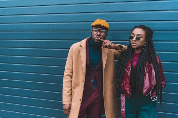 Schönes stylisches junges afrikanisch-amerikanisches Paar schaut weg, während es draußen zusammen steht — Stockfoto