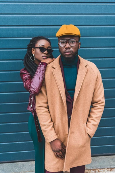 Jovem e elegante casal afro-americano olhando para a câmera enquanto posam juntos na rua — Fotografia de Stock