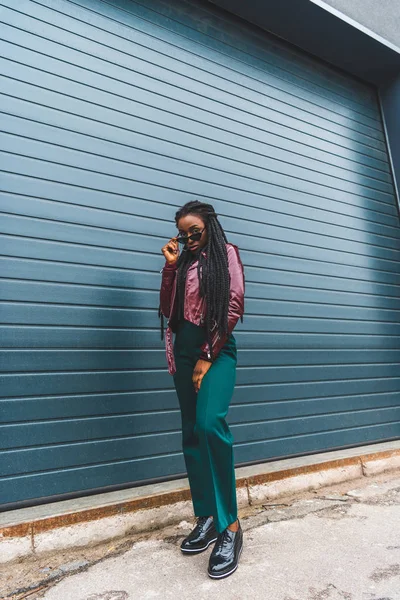 Full length view of beautiful stylish young african american woman in sunglasses posing on street — Stock Photo