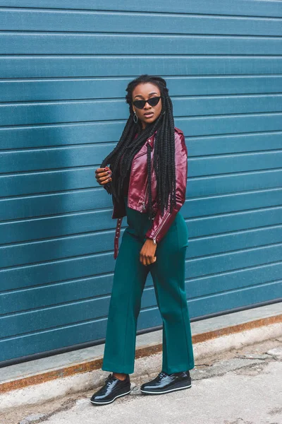 Schöne stilvolle junge afrikanisch-amerikanische Frau mit Sonnenbrille zu Fuß auf der Straße — Stockfoto
