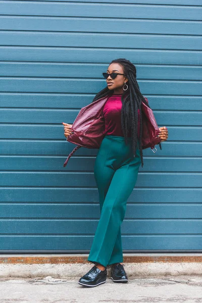 Hermosa joven afroamericana mujer en gafas de sol posando en la calle - foto de stock