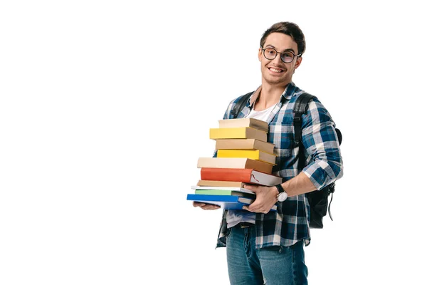 Smiling handsome student holding stack of books isolated on white — Stock Photo