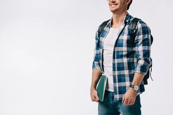 Imagen recortada de estudiante sonriente sosteniendo copybook aislado en blanco - foto de stock