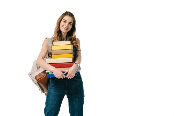 Sorridente bella studentessa tenendo pila di libri isolati su bianco — Foto stock