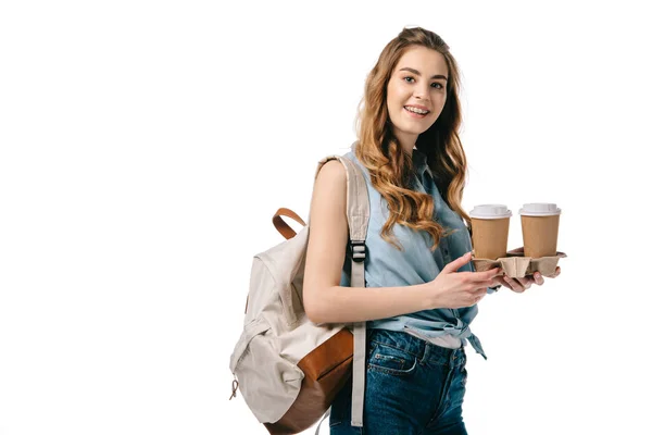 Bela estudante segurando café em copos de papel e olhando para a câmera isolada no branco — Fotografia de Stock