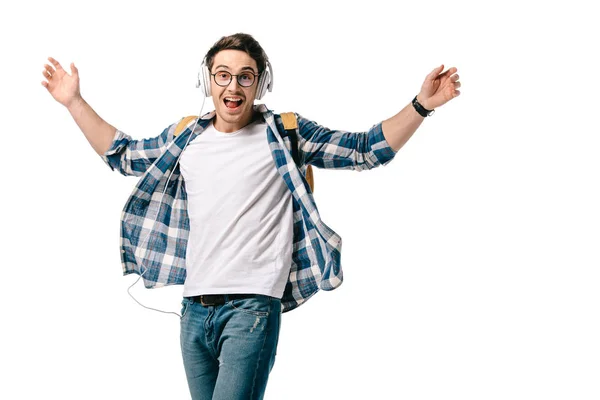 Lächelnde hübsche Studentin, die Musik hört und isoliert auf Weiß tanzt — Stockfoto