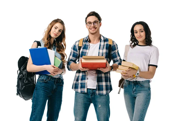 Lächelnde multikulturelle Studenten mit Büchern, die isoliert auf weiß in die Kamera schauen — Stockfoto