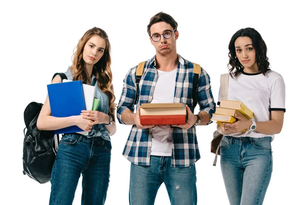 Upset multicultural students with books looking at camera isolated on white — Stock Photo