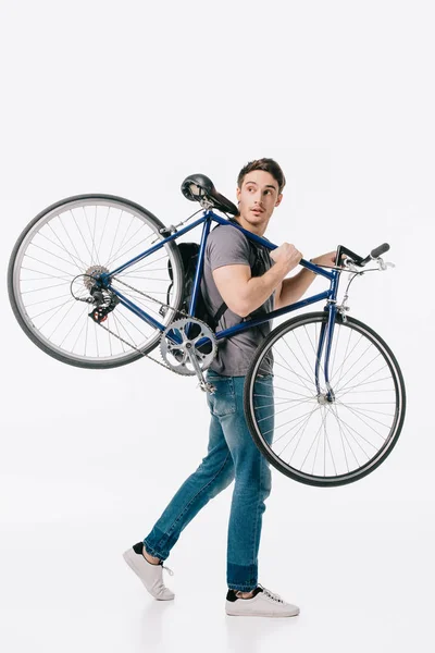Handsome student holding bicycle on shoulder isolated on white — Stock Photo