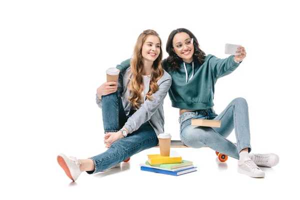 Estudiantes multiculturales sonrientes tomando selfie con teléfono inteligente aislado en blanco - foto de stock