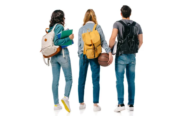Задний вид мультикультурных студентов с рюкзаками и баскетбольный мяч изолированы на белом — стоковое фото