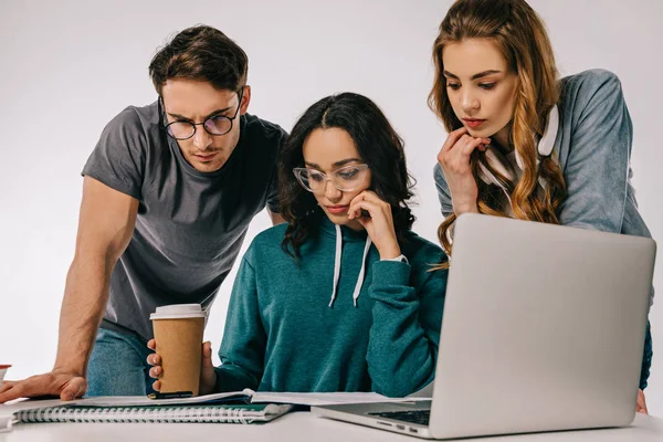 Estudantes multiculturais pensativos olhando para copybook isolado em branco — Fotografia de Stock