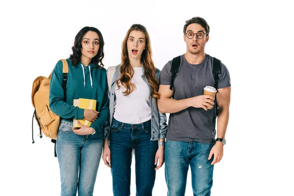 Shocked multicultural students looking at camera isolated on white — Stock Photo