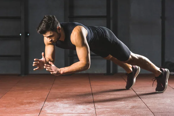 Young sportsman doing push ups  in sports hall — Stock Photo