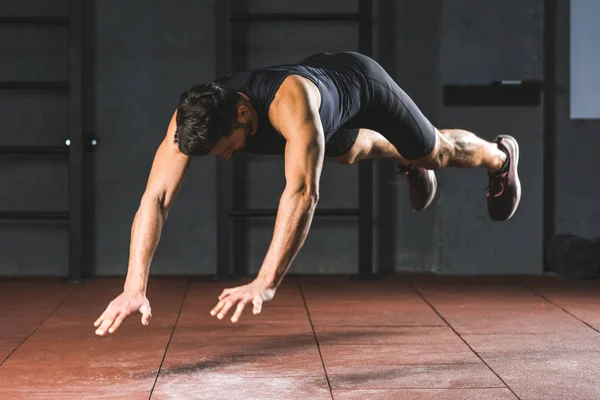 Young sportsman doing push ups  in sports hall — Stock Photo