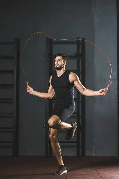 Young sportsman doing jump rope workout in gym — Stock Photo