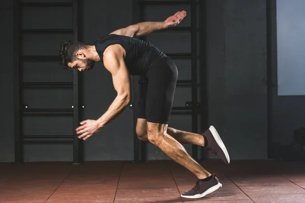 Side view of young sportsman running in sports center — Stock Photo