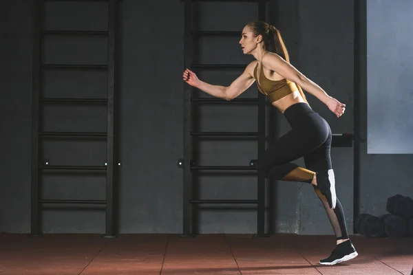 Side view of young sportswoman running in sports center — Stock Photo