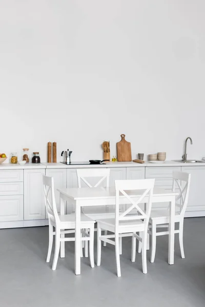 Mesa de comedor en la cocina moderna con paredes de ladrillo blanco — Stock Photo