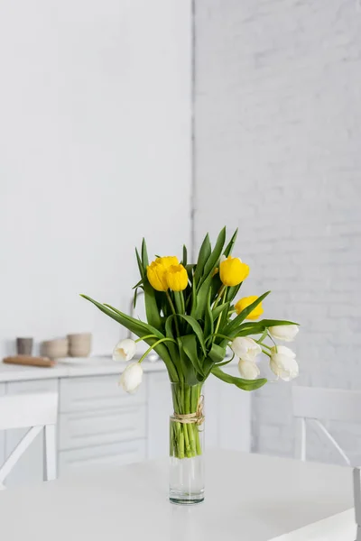 Beautiful tulip flowers in vase on table at modern kitchen — Stock Photo