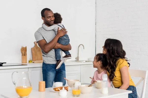 Happy young family at kitchen in morning — Stock Photo