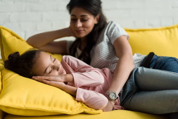 Felice madre guardando come sua figlia dormire sul divano — Foto stock