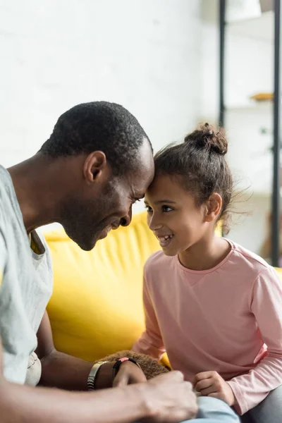 Feliz padre e hija mirándose el uno al otro y tocándose la frente - foto de stock