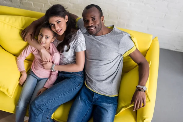 Vue grand angle de jeune famille heureuse relaxant sur canapé confortable — Photo de stock
