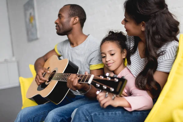 Homme jouant de la guitare pour femme et fille à la maison — Photo de stock