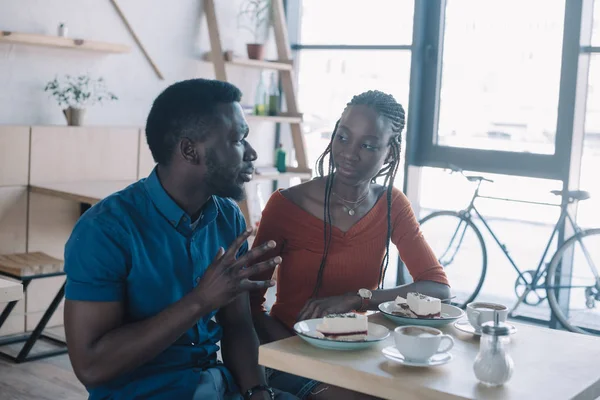 Оскорбленный африканский американец, сидящий за столом с подружкой в кафе — стоковое фото