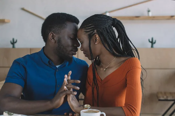 Retrato de tierna pareja afroamericana en cita romántica en cafetería - foto de stock