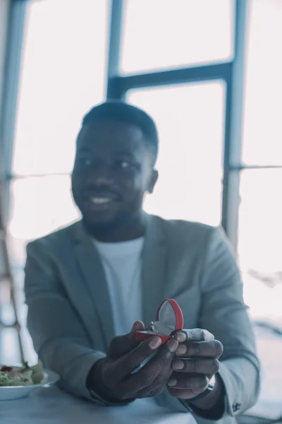 Selective focus of african american man with wedding ring at table in restaurant — Stock Photo