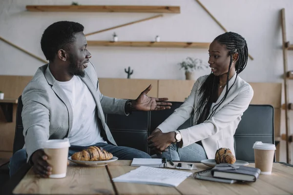 Side view of african american business partners having conversation at table in coffee shop — Stock Photo