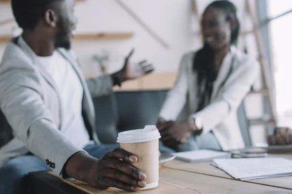 Selective focus of african american businessman with coffee to go on meeting in caef — Stock Photo