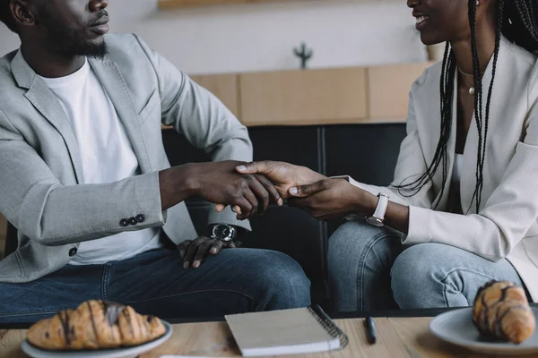 Vue partielle des partenaires commerciaux afro-américains serrant la main lors d'une réunion d'affaires dans un café — Photo de stock