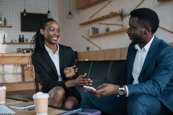 Retrato de socios de negocios afroamericanos sonrientes conversando en cafetería - foto de stock