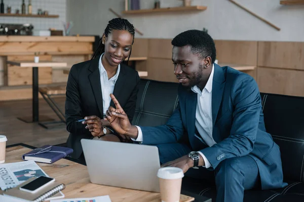 African american businesspeople using laptop together in cafe — Stock Photo