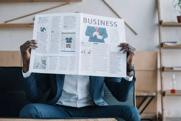 Obscured view of african american businessman with newspaper in cafe — Stock Photo