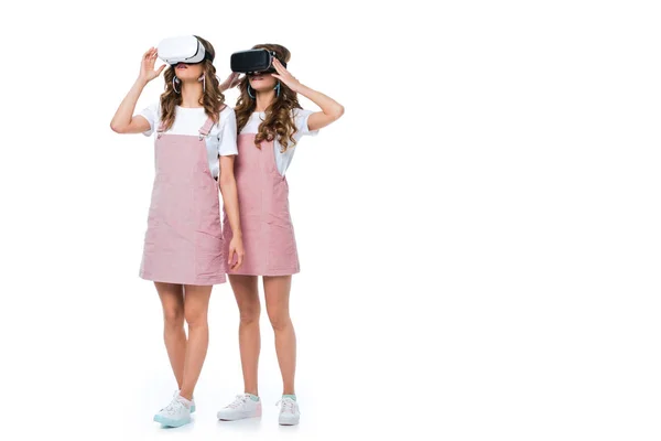 Gêmeos jovens usando fones de ouvido de realidade virtual isolados em branco — Fotografia de Stock