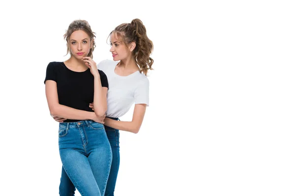 Smiling attractive young twin looking at confident sister isolated on white — Stock Photo