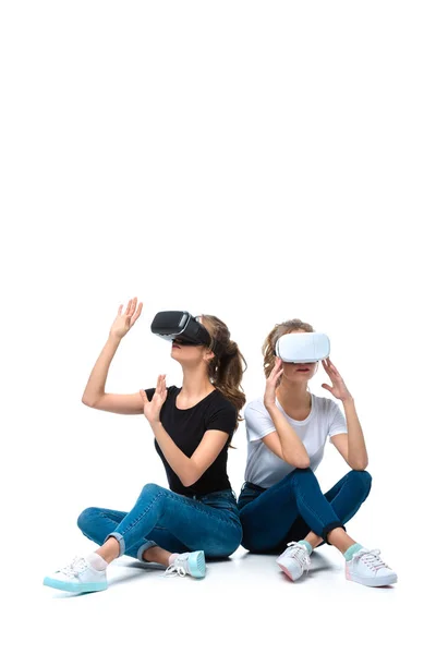 Young twins sitting and using virtual reality headsets on white — Stock Photo