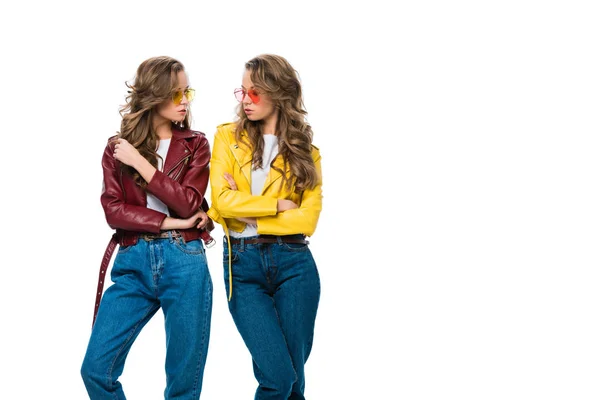 Attractive stylish twins in leather jackets and sunglasses looking at each other isolated on white — Stock Photo