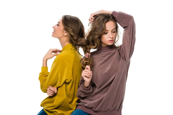 Attractive young twins with hair in one braid isolated on white — Stock Photo