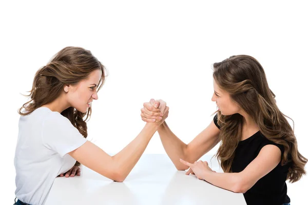Side view of angry twins armwrestling at table isolated on white — Stock Photo