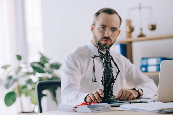Вибірковий фокус адвоката в окулярах з фемідою на робочому місці в офісі — стокове фото